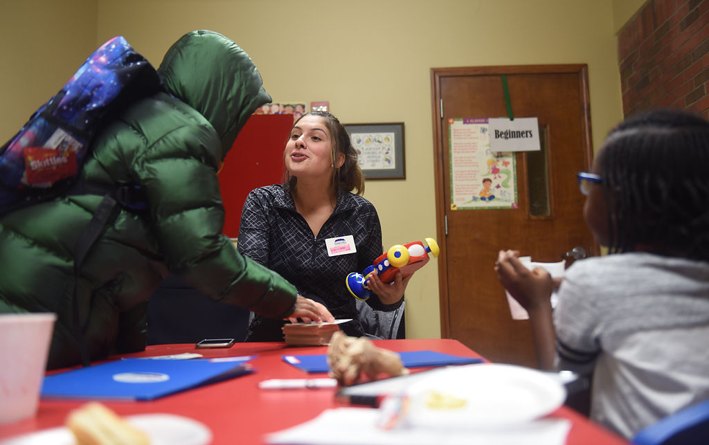 Emilee Dent teaches time to De'Shaun Linzie, left, and Lyla Oluoch